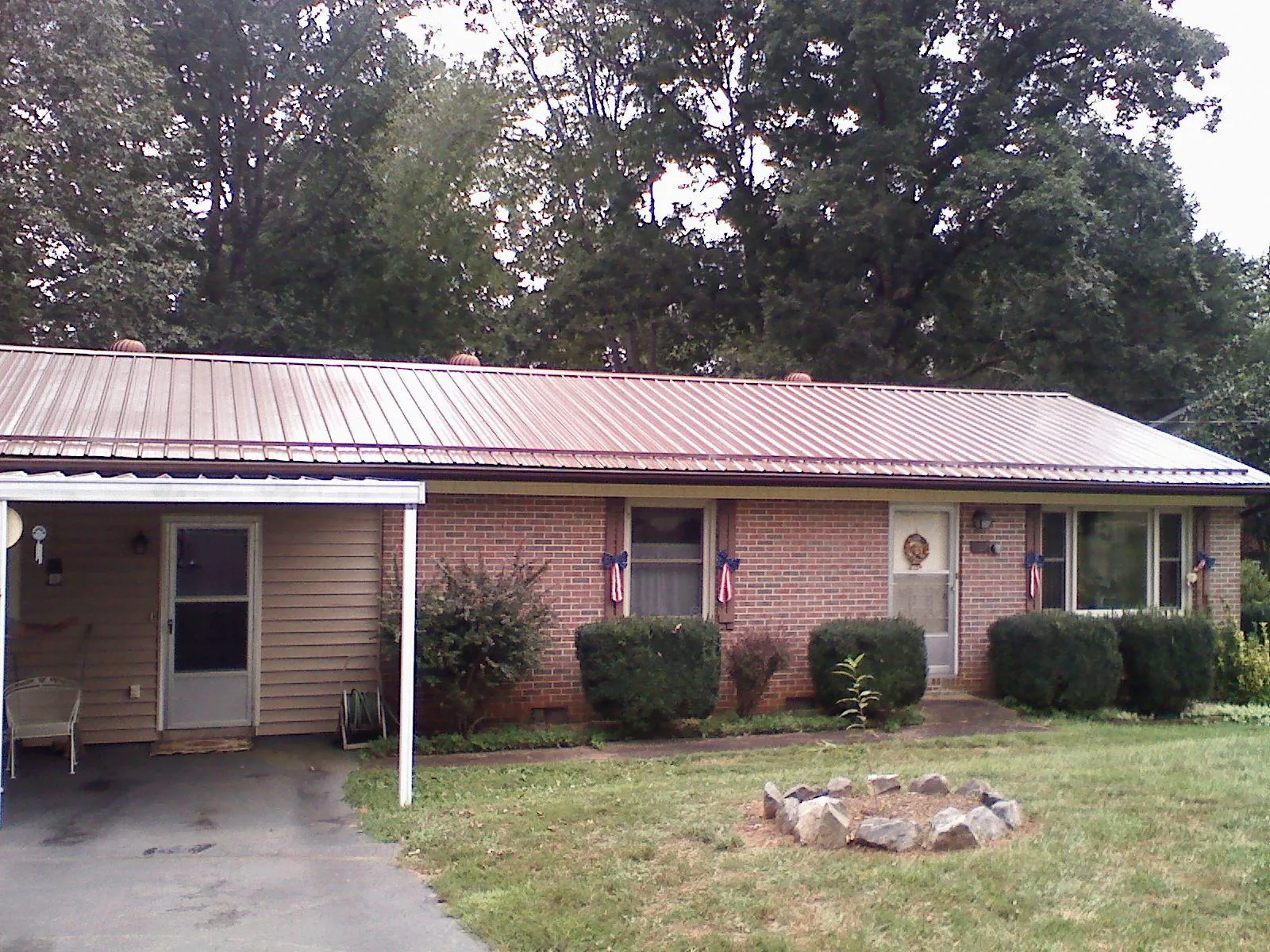 Bronze metal roof and carport on a brick ranch home — Roof Repair work by our crew in Coalmont